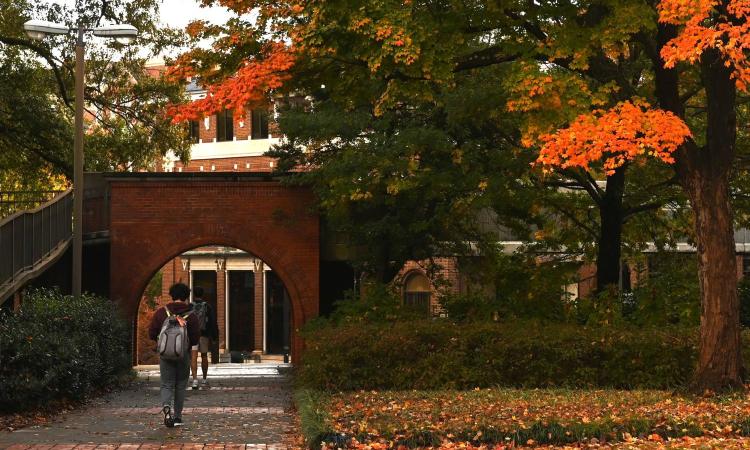 A young man crossing a brick archway at Georgia Tech.
