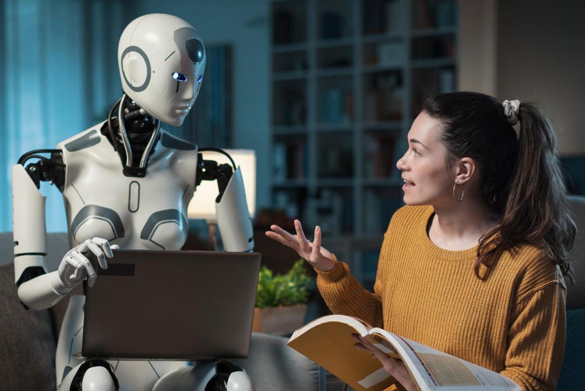 A humanoid with a computer listens to a woman talking.