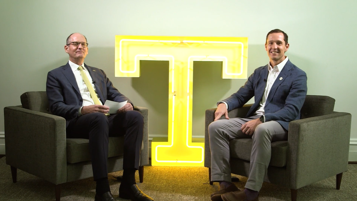 Provost Steve McLaughlin and Rick Clark are sitting and looking at the camera. A bright yellow T is in between them.